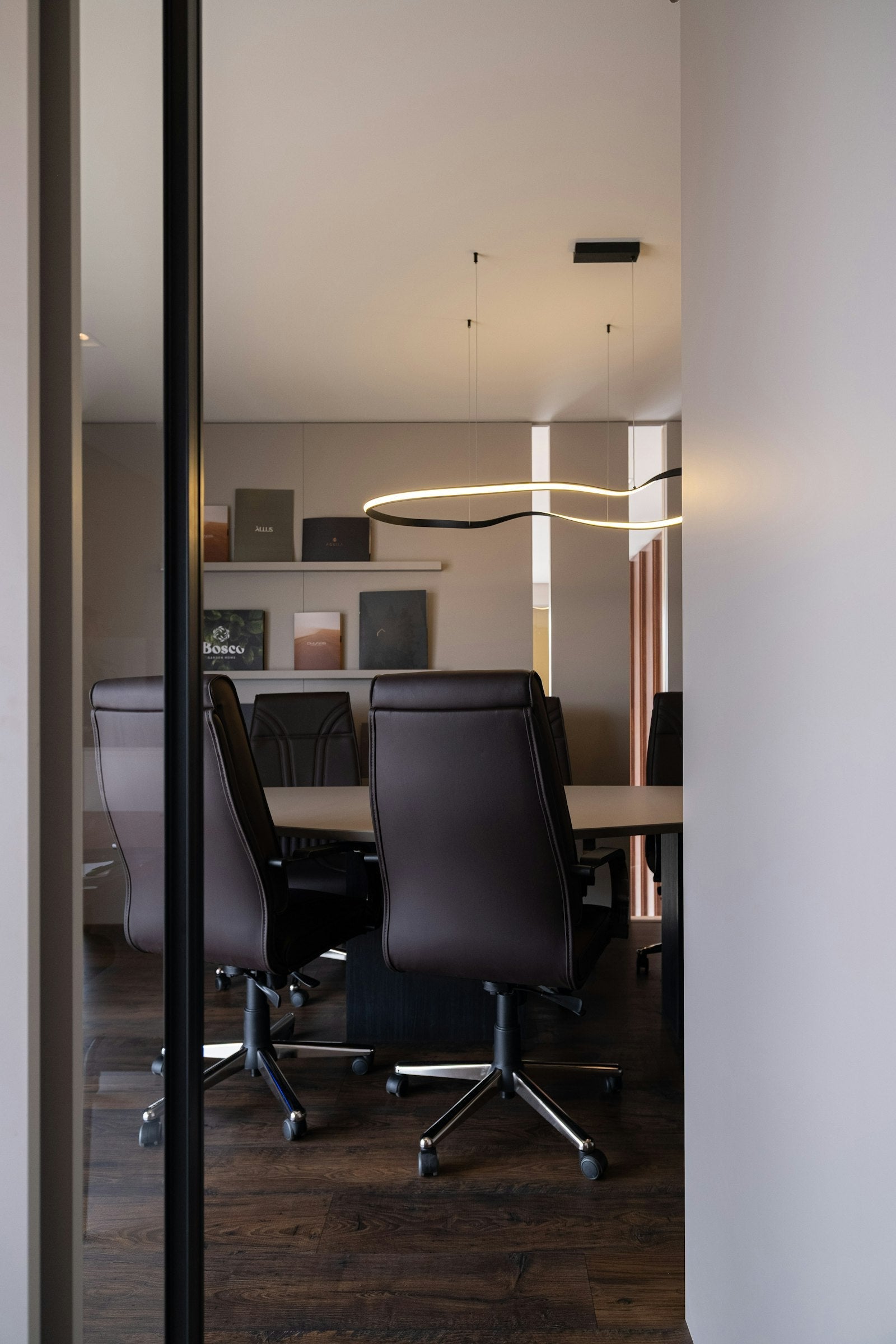 Corporate boardroom with leather chairs and a large wall-mounted display for meetings